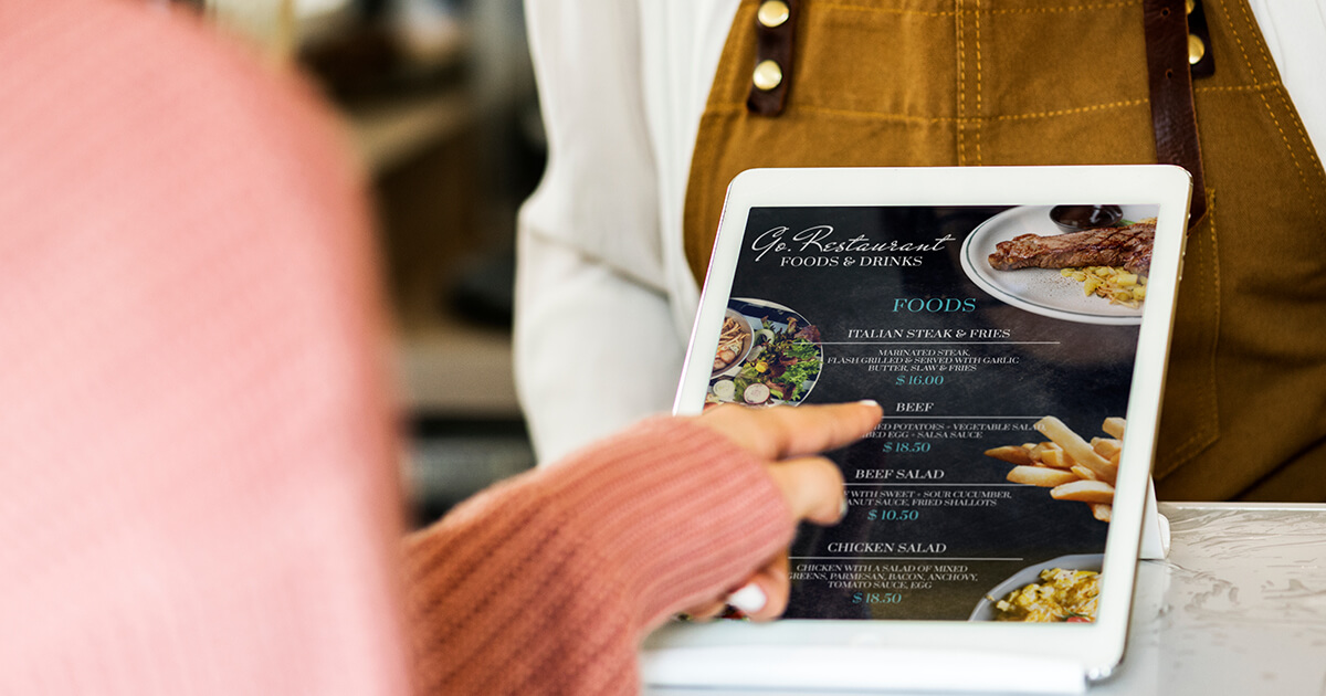 Customer using a digital food menu at a restaurant counter